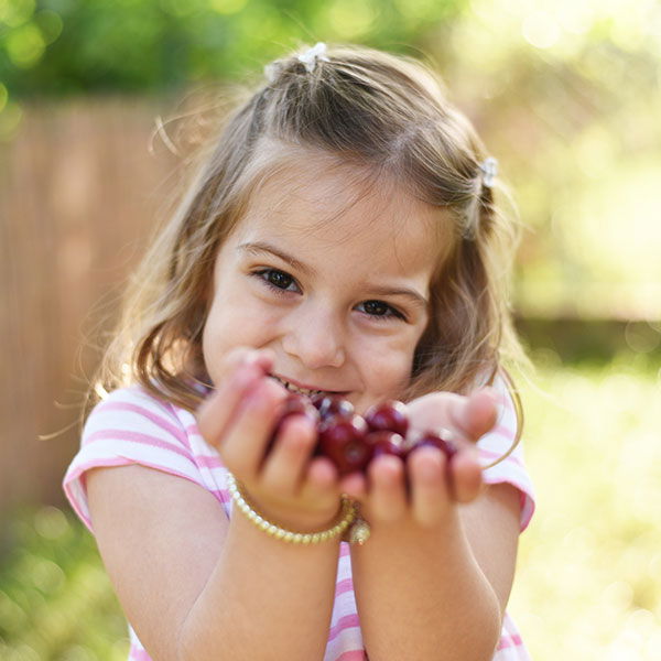 little girl with cherries